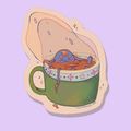 A sticker og a wee blue goblin floating in a cup of tea for a nice spa.