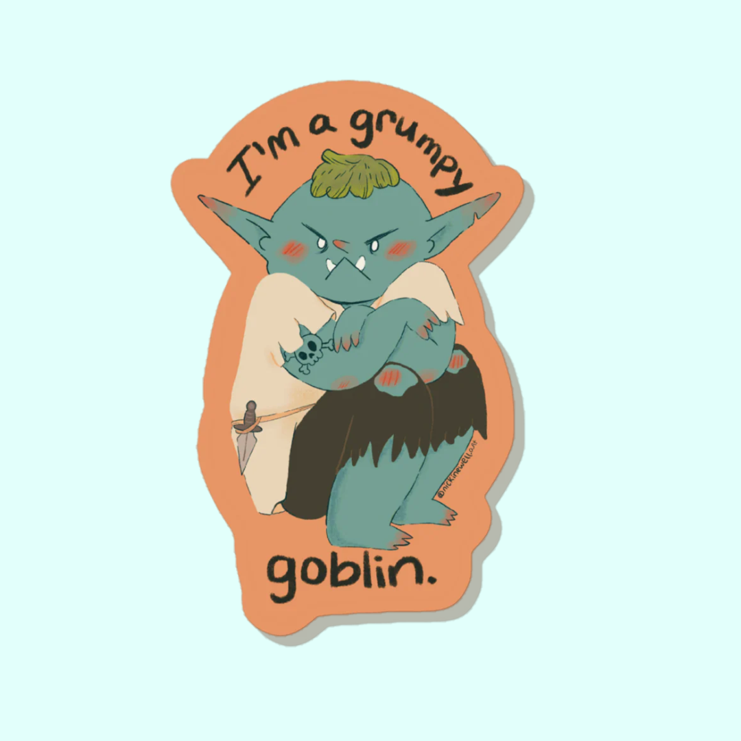 A sticker with an orange background sitting on op of a light blue background. The sticker is an illustration of a teal goblin sitting with their arms crossed and frowning. the sticker says "I'm a grumpy goblin." 