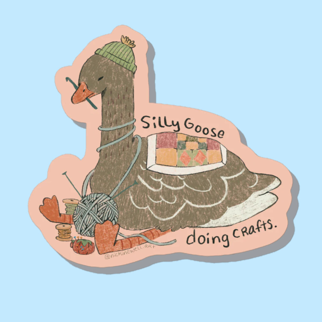 A sticker of a brown goose with a crochet hook held in their beak, and surrounded by other fiber arts tools as well as wearing a quilt on their back and green knitted hat on their head.